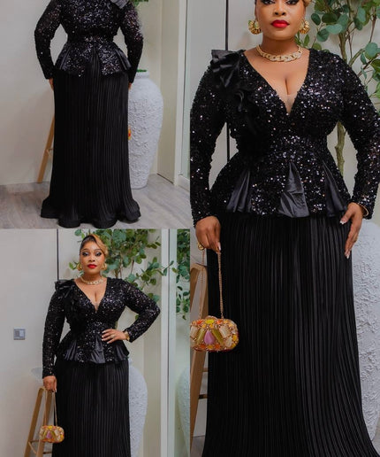 Woman wearing a black sequin top and pleated skirt with a gold handbag indoors.