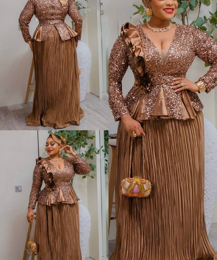 Woman in a sparkling gold outfit with a pleated skirt, posing indoors.